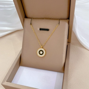 Gold titanium steel circle necklace with black pendant and crystals in a beige gift box