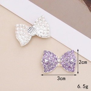 Macro view of 3x2cm bow charms with silver texture and purple rhinestones, weighing 6.5g