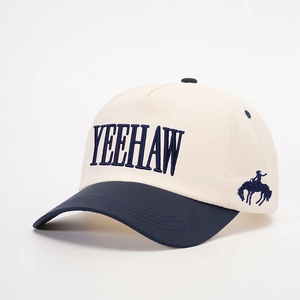 Close-up detail of YEEHAW embroidery and cowboy motif on a bicolor cotton baseball cap
