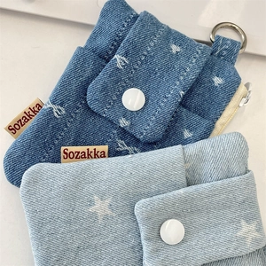 Close-up of denim card holders with star patterns and sturdy metal button closures