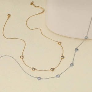 Detail of elegant gold and silver stainless steel heart necklaces with zircon stones