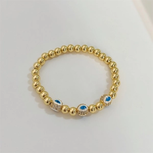 Detailed view of 18K gold-plated beaded bracelet with micro-pave zircon evil eye charms