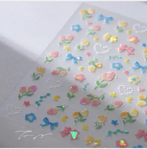 Macro shot of 3D iridescent laser nail stickers with floral, star, and moon patterns