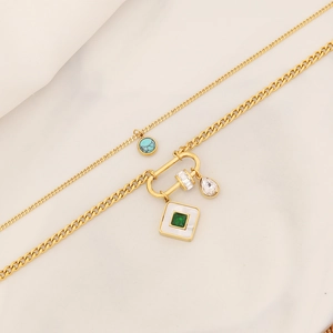 Detail of gold double-layer necklace with turquoise pendant and emerald-cut stones