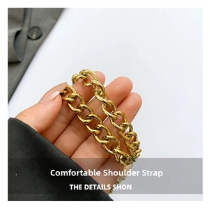 Detail of chunky gold chain strap on denim crossbody bag showing metallic luster and texture