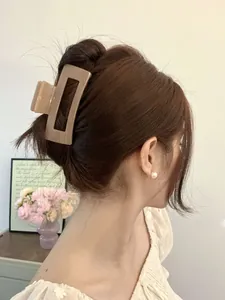 Detail shot of light brown rectangular hair claw clip in a stylish updo hairstyle
