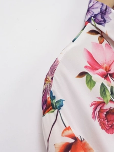 Gros plan sur l'imprimé floral rose et rouge sur un tissu en popeline blanche de qualité