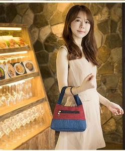 Lifestyle shot of a red and blue color-block canvas lunch bag held by a model
