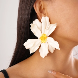 Close-up of model wearing large white acrylic flower earrings with yellow stamen