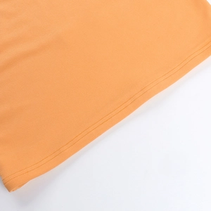 Detail von orangefarbenem Rippstrick mit hochwertigen Nähten an einem figurbetonten Kleid