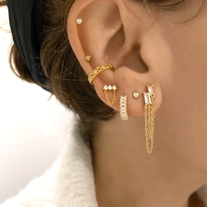 Gold layered earrings set with cubic zirconia and fringe chain on ear lobe