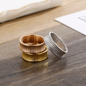Detailed close-up of three striped 18K gold plated rings in gold, silver, and rose gold