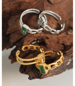 Macro detail of twisted rope and chain texture rings with green and white zircon stones