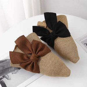 Detail of woven straw fisherman hat with large black and brown fabric bow accents