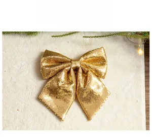 Detail of large gold sequin Christmas bow decoration on festive background