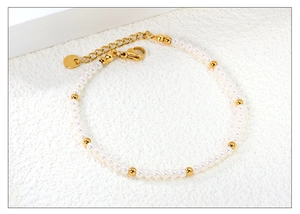 Macro shot of 18K gold-plated stainless steel pearl bracelet with lobster clasp and chain