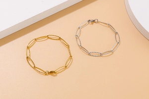 Detailed close-up of gold and silver textured oval link bracelets on geometric props