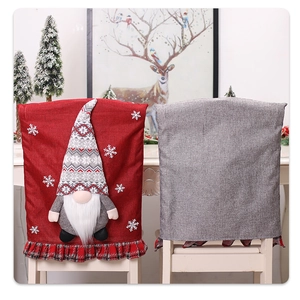 Detailed close-up of red and grey festive Christmas gnome chair covers on white dining chairs