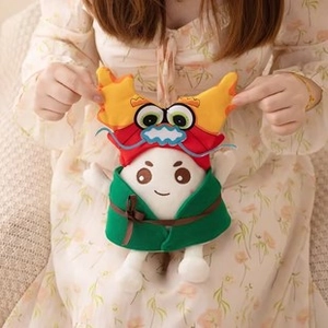 Detailed plush teddy bear wearing a dragon hat and green robe held by a person