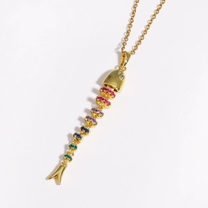Detail of a golden fishbone pendant featuring colorful gemstones and a movable body