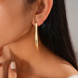 Détail d'une boucle d'oreille barre minimaliste plaquée or 18 carats sur le mannequin