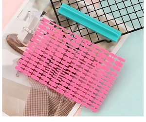 Close-up of pink silicone baking mat and blue tool holder on a decorative surface