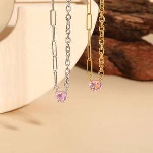 Détail de pendentifs cœur rose sur chaînes trombones en finitions dorée et argentée