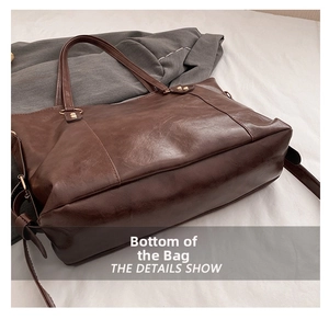 Detail view of the brown tote bag bottom showing smooth leather and durable stitching