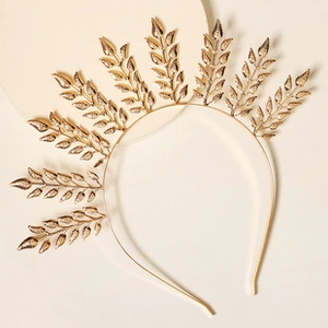 Detailed view of a golden metal leaf headband with a radiant crown design