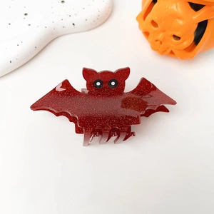 Detail of red glitter bat hair claw clip with eyes for Halloween hairstyles