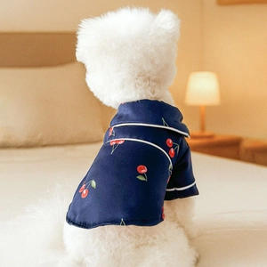 Silk-textured dark blue cherry print pet pajamas for small dogs and cats on a bed