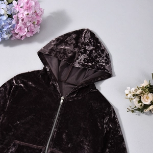 Detail of soft velvet hoodie in dark brown color with smooth metal zipper and plush hood