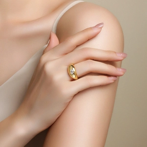 Close-up of a wide gold plated silver ring featuring a sparkling oval moissanite stone