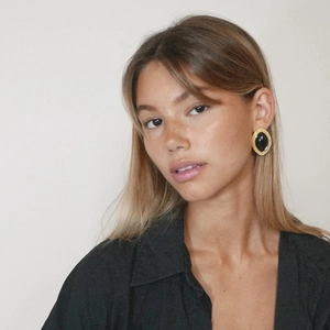Close-up of vintage 18k gold plated stainless steel black onyx marquise earrings on model