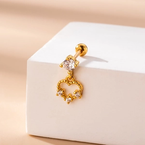 Gros plan d'un piercing d'oreille en acier doré avec cœur évidé et pierres de zircon