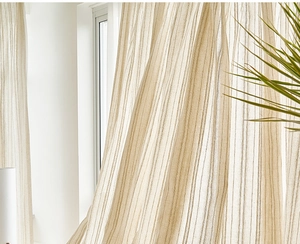 Close-up of beige linen curtain fabric with natural texture and soft light filtering