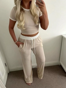 Detail of knitted ribbed two-piece set featuring short sleeve crop top and wide leg pants