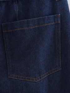Vue détaillée du tissu denim bleu foncé avec une poche classique et des surpiqûres