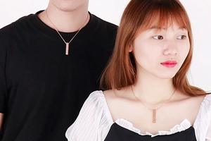 Gros plan du pendentif rectangulaire en or rose avec strass en cœur sur un couple