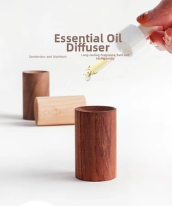 Gros plan d'huile essentielle versée sur un diffuseur en bois cylindrique naturel