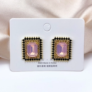 Detailed macro view of vintage rectangular pink gemstone earrings with black accents