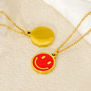 Golden stainless steel necklace featuring a dual-sided red smiley face pendant charm