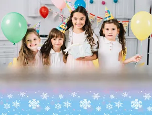 Pink to blue gradient party tablecloth featuring white snowflake patterns and festive stars