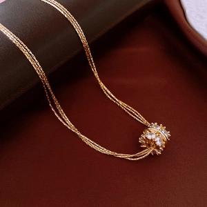 Macro-opname van vergulde meerlaagse ketting met sprankelende zirkonia cilindrische hanger