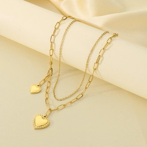Detail shot of golden double-layer heart necklace with paperclip and fine chains
