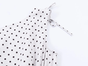 Detail of white polka dot top showing stitching on the neckline and tie-up straps