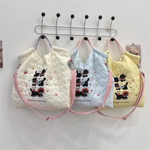 Detailed close-up of heart quilted fabric bags with cartoon embroidery and adjustable straps
