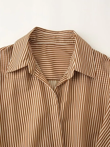 Close-up of the classic brown and white striped collar and stitching on the dress