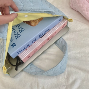 Close-up of quilted tote bag interior showing large capacity and yellow lining