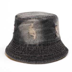Detailed view of frayed holes and metal logo badge on vintage denim bucket hat